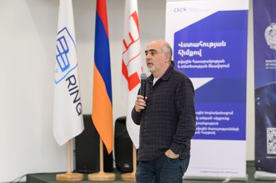 Սամվել Մարտիրոսյանը խոսում է, ետևում դրոշներ են